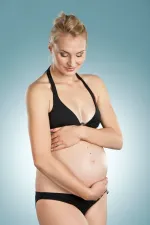 FloWü - Schwangerschaft Schwangere Frau umfasst liebevoll und zärtlich das Baby in ihrem Bauch